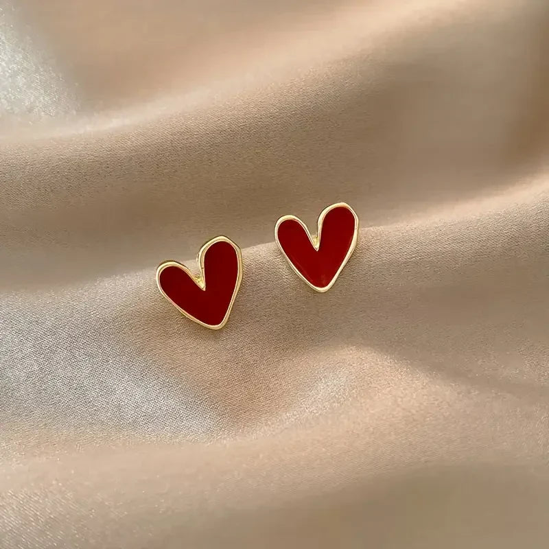 Elegant gold earrings with antique red hearts